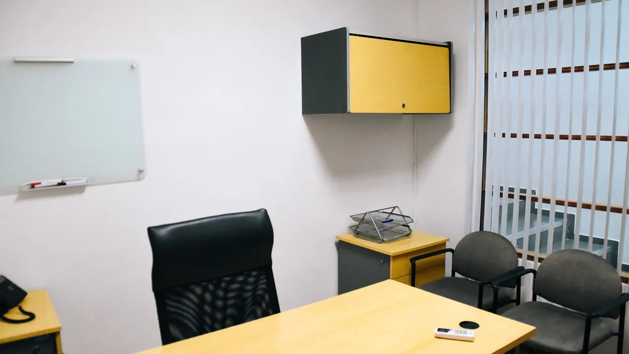 Un bureau de responsable, son fauteuil et deux chaises pour les visiteurs